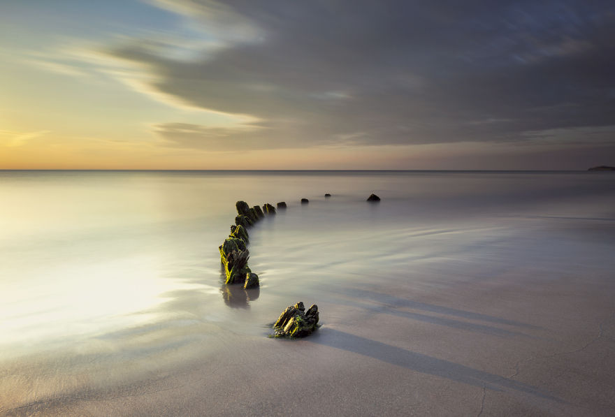 old shipwreck on beach at sunrise