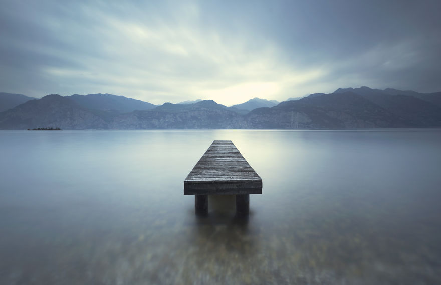 lake with pier in mountains in italy